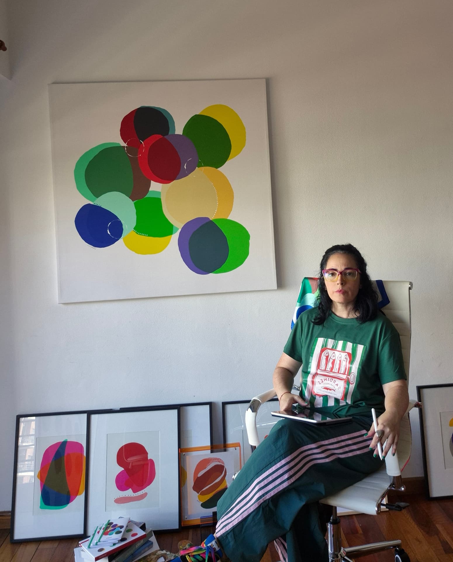 Caro Aranda en su studio, frente a una obra de círculos